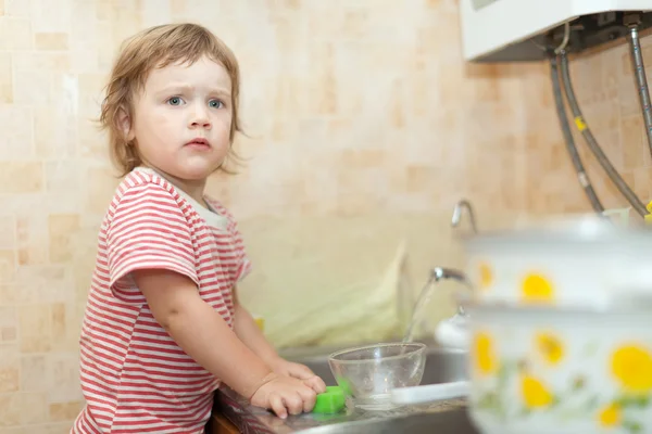 Маленькая девочка моет посуду — стоковое фото