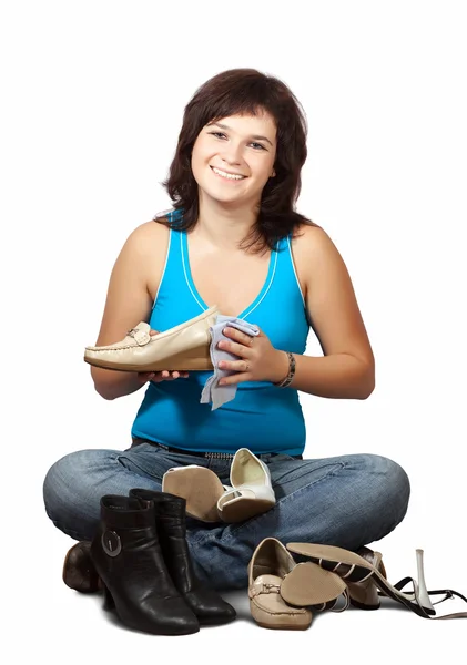 Woman and cleans shoes over white — Stock Photo, Image