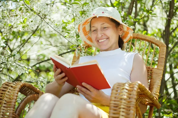 Mature woman in blossoming garden — Stock Photo, Image