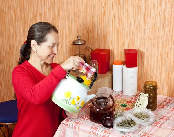 Mature woman brews herbs — Stock Photo, Image