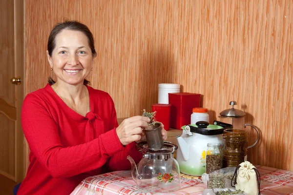 Mature woman brews herbs — Stock Photo, Image