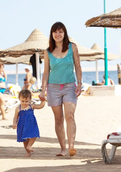 Madre con niño pequeño caminando en la playa — Foto de Stock