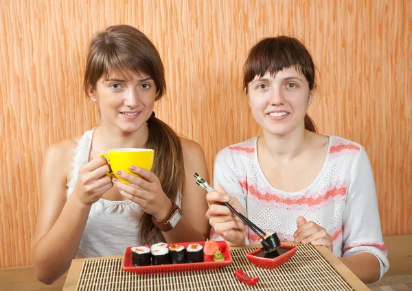 Kvinnor äter sushi rullar — Stockfoto