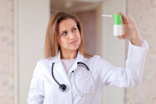 O médico olha fixamente para o spray — Fotografia de Stock