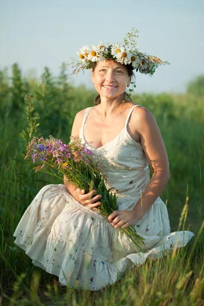 Mature woman gathers herbs — Stock Photo, Image