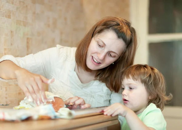 Mutlu anne ile kızı somon pişirme — Stok fotoğraf