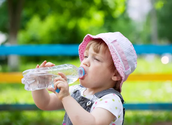 Iki yıllık çocuk plastik şişe içki içer. — Stok fotoğraf