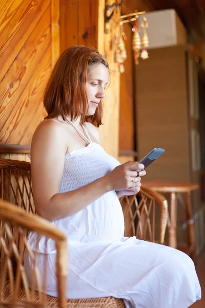 Zwangere vrouw leest e-boek — Stockfoto