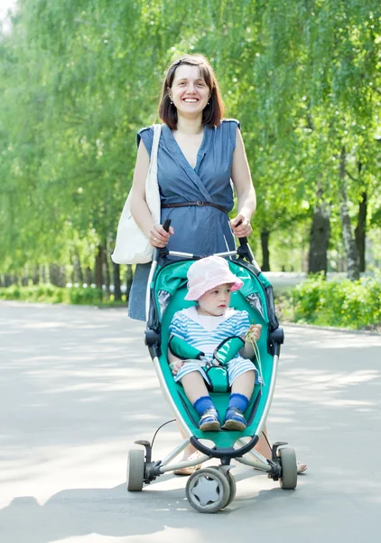 Femme marche avec poussette bébé — Photo