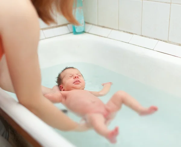 Mãe banha bebê recém-nascido — Fotografia de Stock