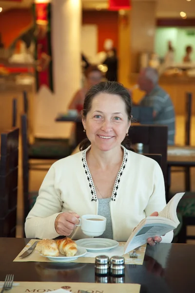 Femme mûre prendre le petit déjeuner — Photo