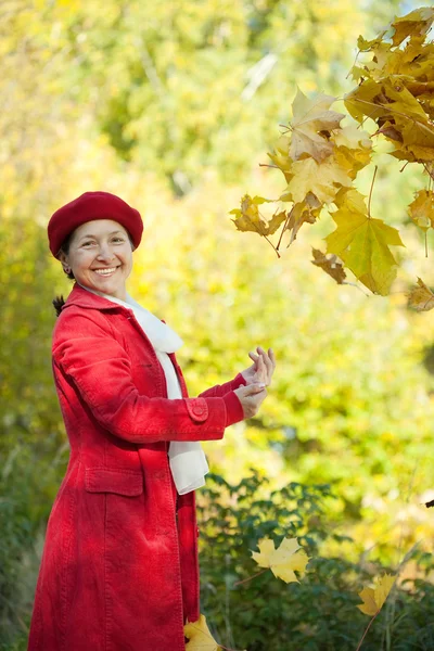 Happy mature woman in autumn park — Stock Photo, Image