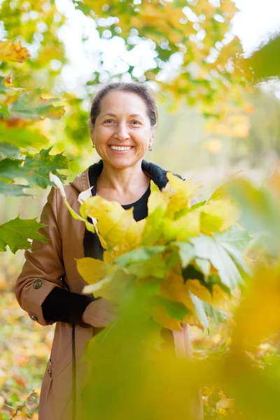 Happy mature woman with maple posy — Stock Photo, Image