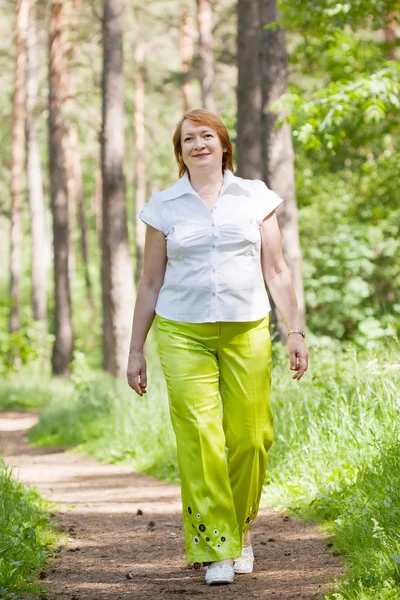 Camminando donna matura nella foresta — Foto Stock