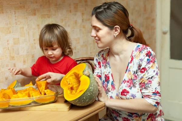 Mother with daughter cooking pumpkin at kitchen — Stock Photo, Image