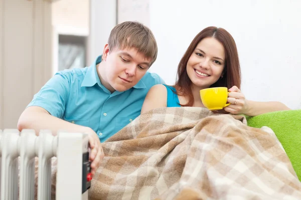 Ehepaar bei warmem Heizkörper in Wohnung — Stockfoto