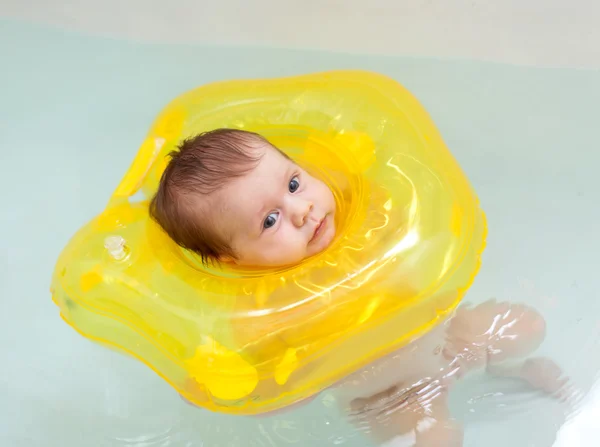 Child swimming with neck swim ring — Stock Photo, Image
