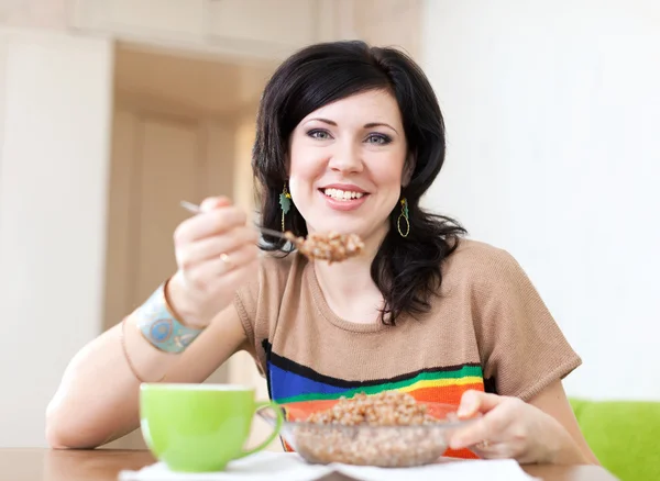 Beauty woman eats buckwheat cereal — Stock Photo, Image