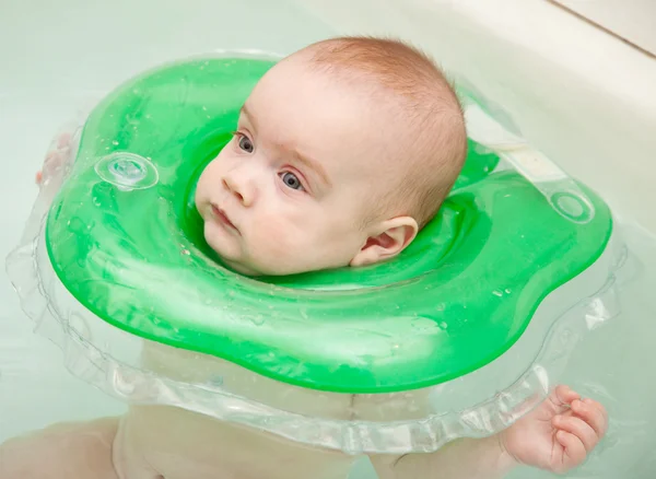 Baby swimming with neck swim ring — Stock Photo, Image