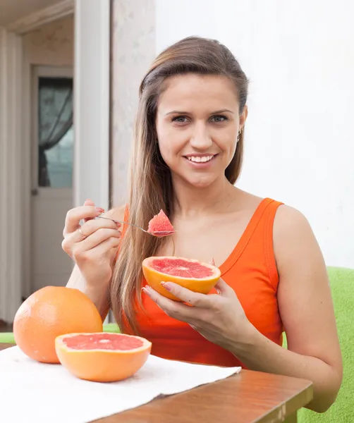 Mooie vrouw grapefruit eten met lepel — Stockfoto