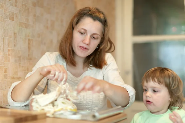 Mujer con niño cocinando comida — Foto de Stock