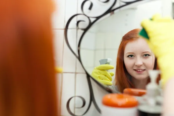 Teen flicka Rengör spegel i badrummet — Stockfoto