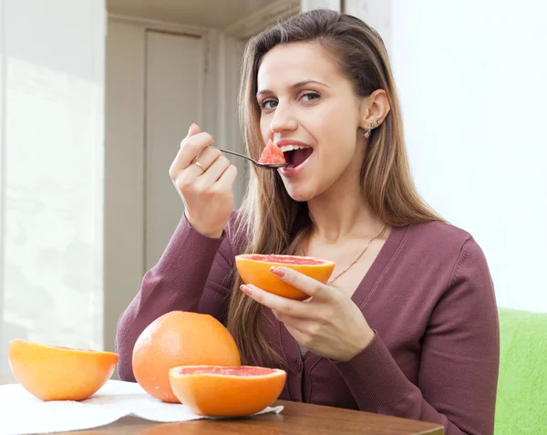 Menina de cabelos longos comendo toranja — Fotografia de Stock