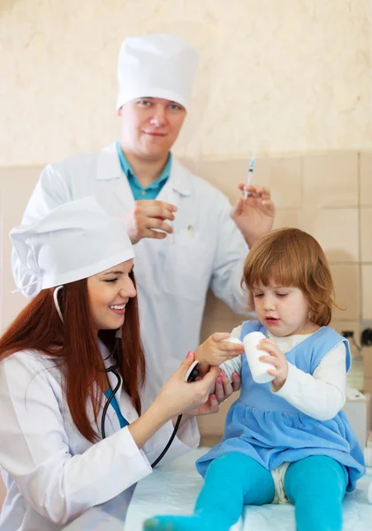 Artsen die werkzaam zijn met babymeisje — Stockfoto