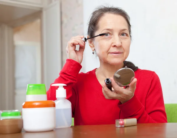 Reife Frau setzt Wimperntusche auf — Stockfoto