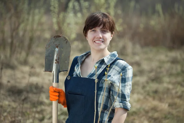 Vrouw met spade en spruit in het voorjaar van — Stockfoto