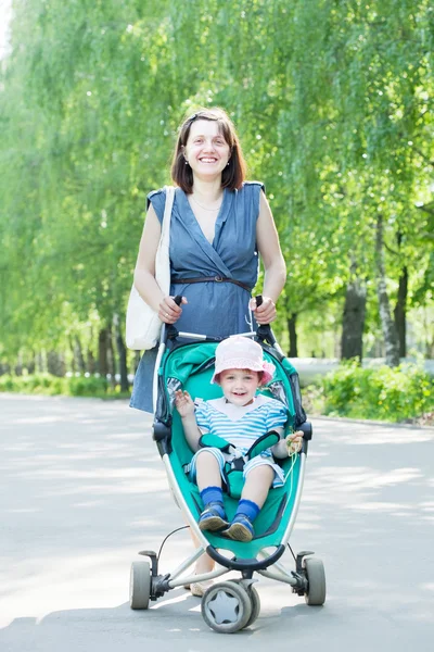 Mother with stroller in summer park — Stock Photo, Image