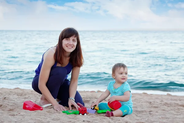 Gelukkig moeder met peuter op strand — Stockfoto
