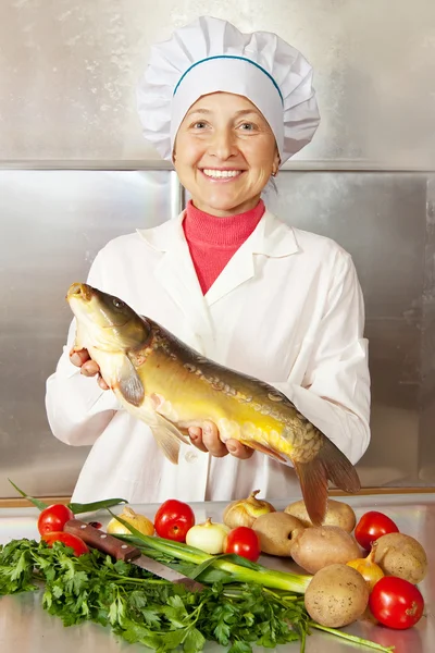 Femme cuisinière avec poisson carpe — Photo