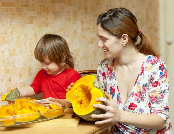 Happy mother with daughter cooking pumpkin — Stock Photo, Image