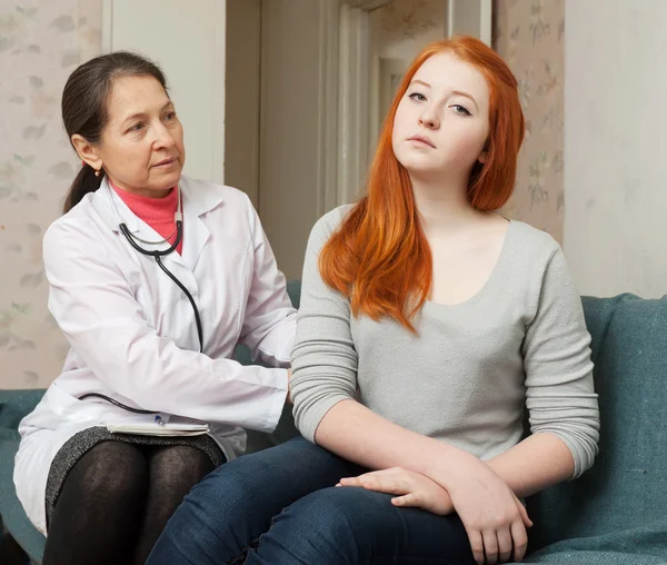 Mature doctor palpates behind of teenager Stock Image