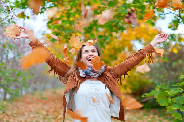 Donna felice getta foglie — Foto Stock