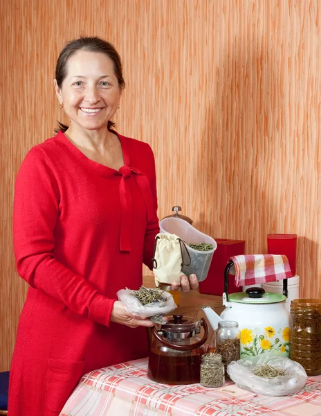 Mature woman brews herbs — Stock Photo, Image