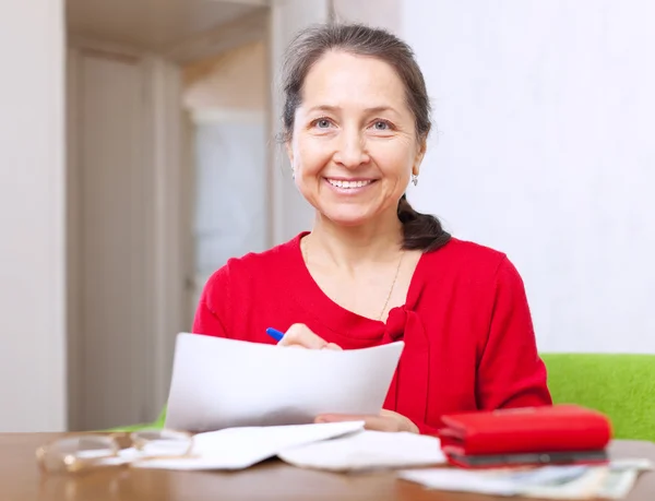 Mulher alegre preenche documentos de pagamento — Fotografia de Stock
