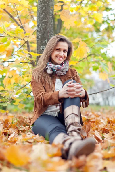 Woman sits in autumn park — Stock Photo, Image