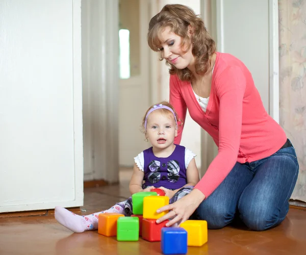 Madre y bebé niña juega con bloques de juguete — Foto de Stock