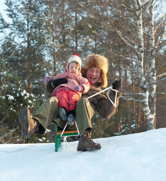 Mann mit Kind auf Schlitten bergab — Stockfoto