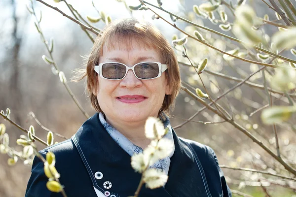Senior woman in spring willow — Stock Photo, Image