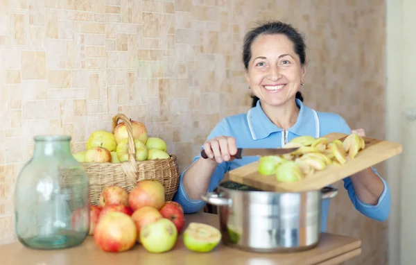 Kvinna kockar äppelmos sylt — Stockfoto