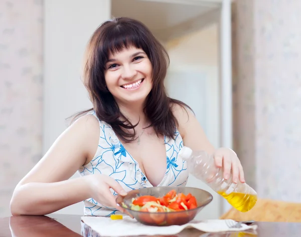 Kadın dökülen petrol sebze salatası — Stok fotoğraf