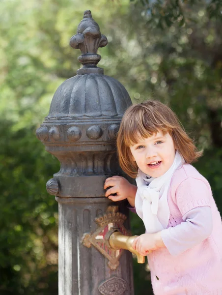 Babymeisje met waterpomp op straat van barcelona — Stockfoto