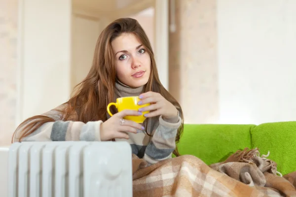 Femme avec tasse jaune près de chauffe-huile — Photo