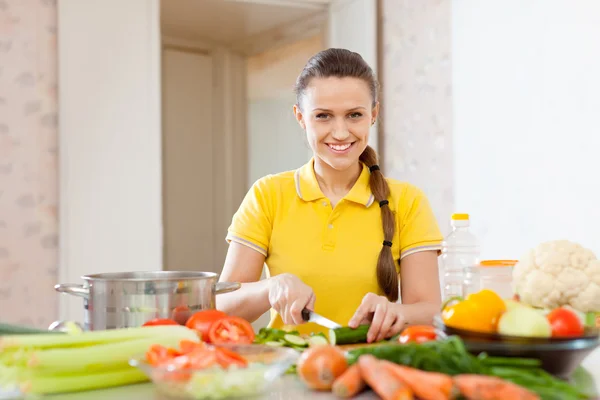 Жінка нарізає овочі на кухні — стокове фото