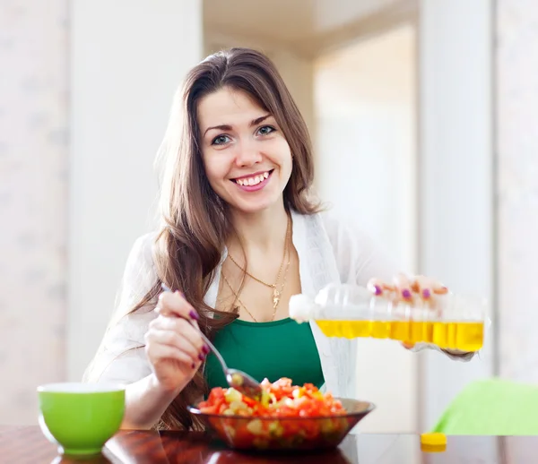 Woman pouring vegetable oil salad — Stock Photo, Image