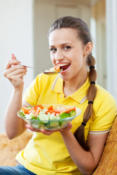 Femme manger salade de légumes sur canapé — Photo