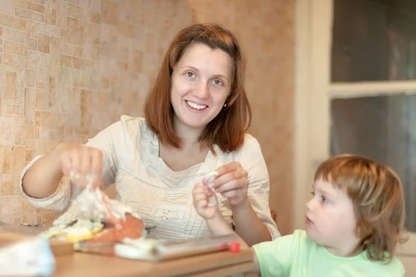 Szczęśliwą matką z cookis dziewczyna w kuchni — Zdjęcie stockowe